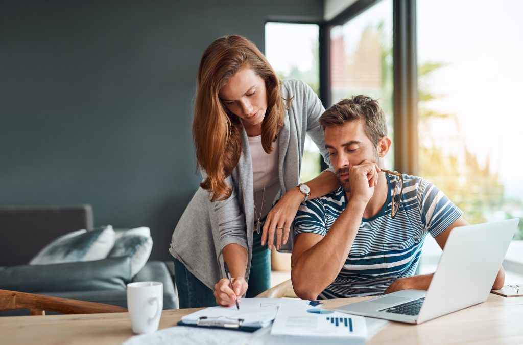 Image of couple reviewing papers and working on computer